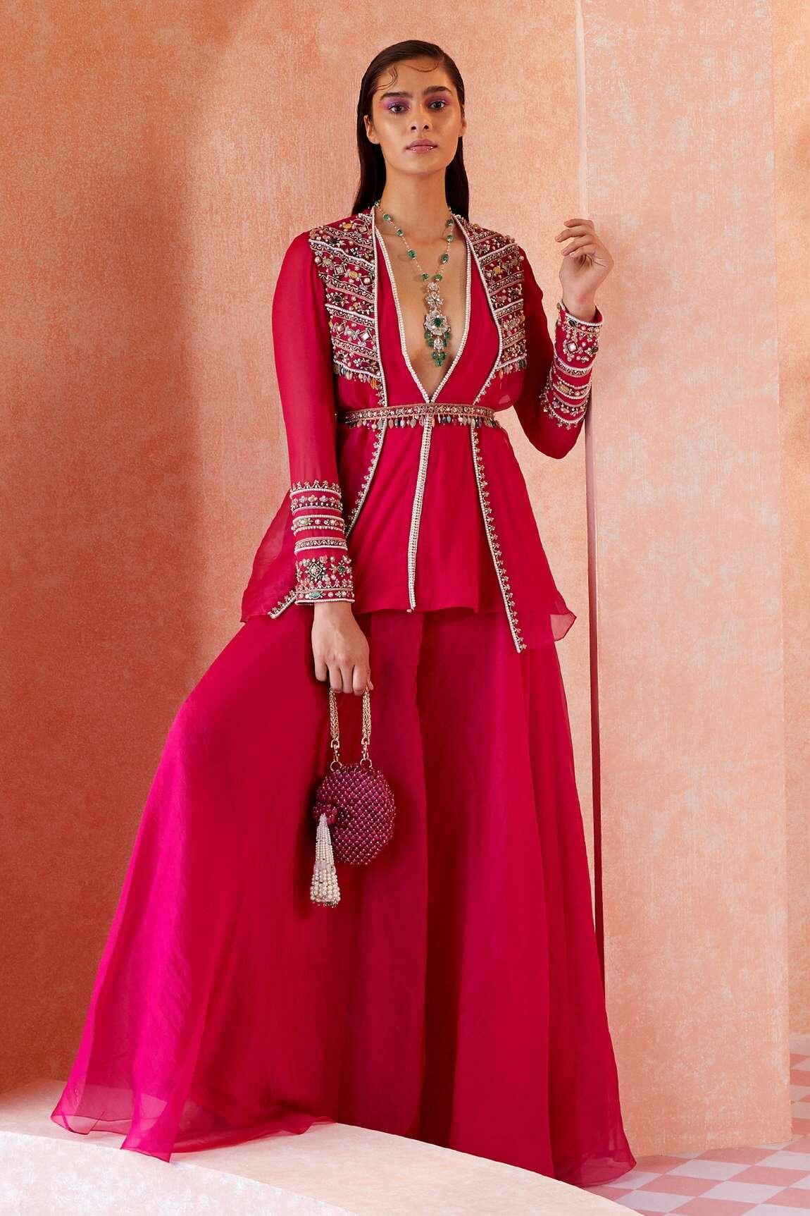 Barbiecore inspired sharara set with jacket from designer ridhi mehra. deep v jacket styled with clutch